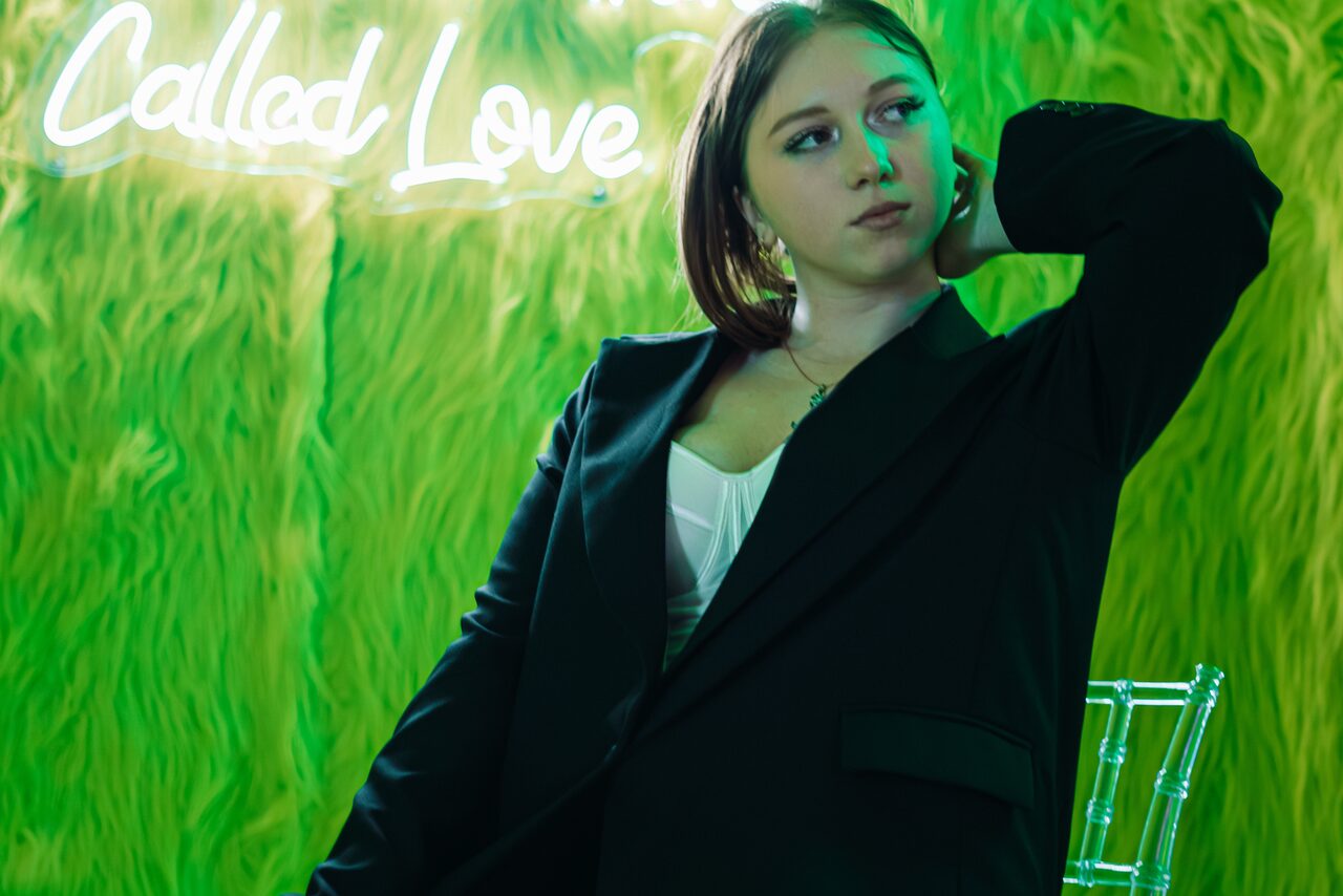 Арендовать Лофт ЗЕФИРКА. Зеленая текстурированная стена с надписью "Called, Love", прозрачный стул.