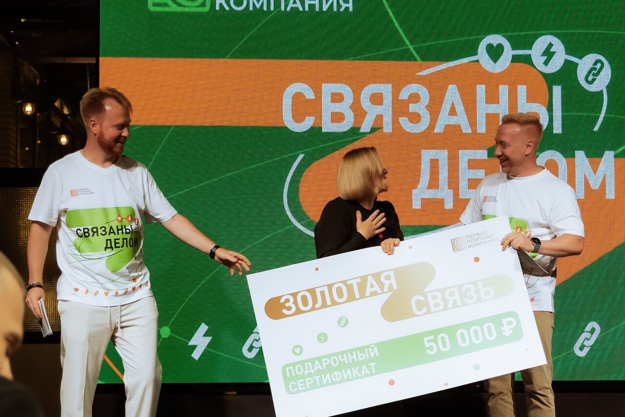 Арендовать Банкетное пространство ресторана площадью 600 м 2 . Люди на сцене держат баннер с надписью "Золотая связь" и подарочным сертификатом на 50,000 ₽. На заднем плане — экран с надписью "Связаны делом". Обстановка выглядит как мероприятие или презентация.