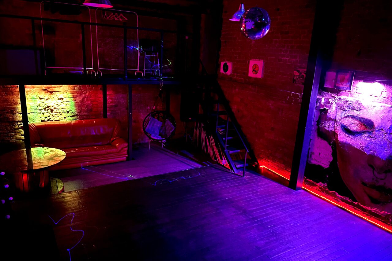 Арендовать Soul Loft . Отдельная комната в лофте с принадлежностями для кальянов, на стене висят виниловые пластинки, на другой стене красками изображён мужчина