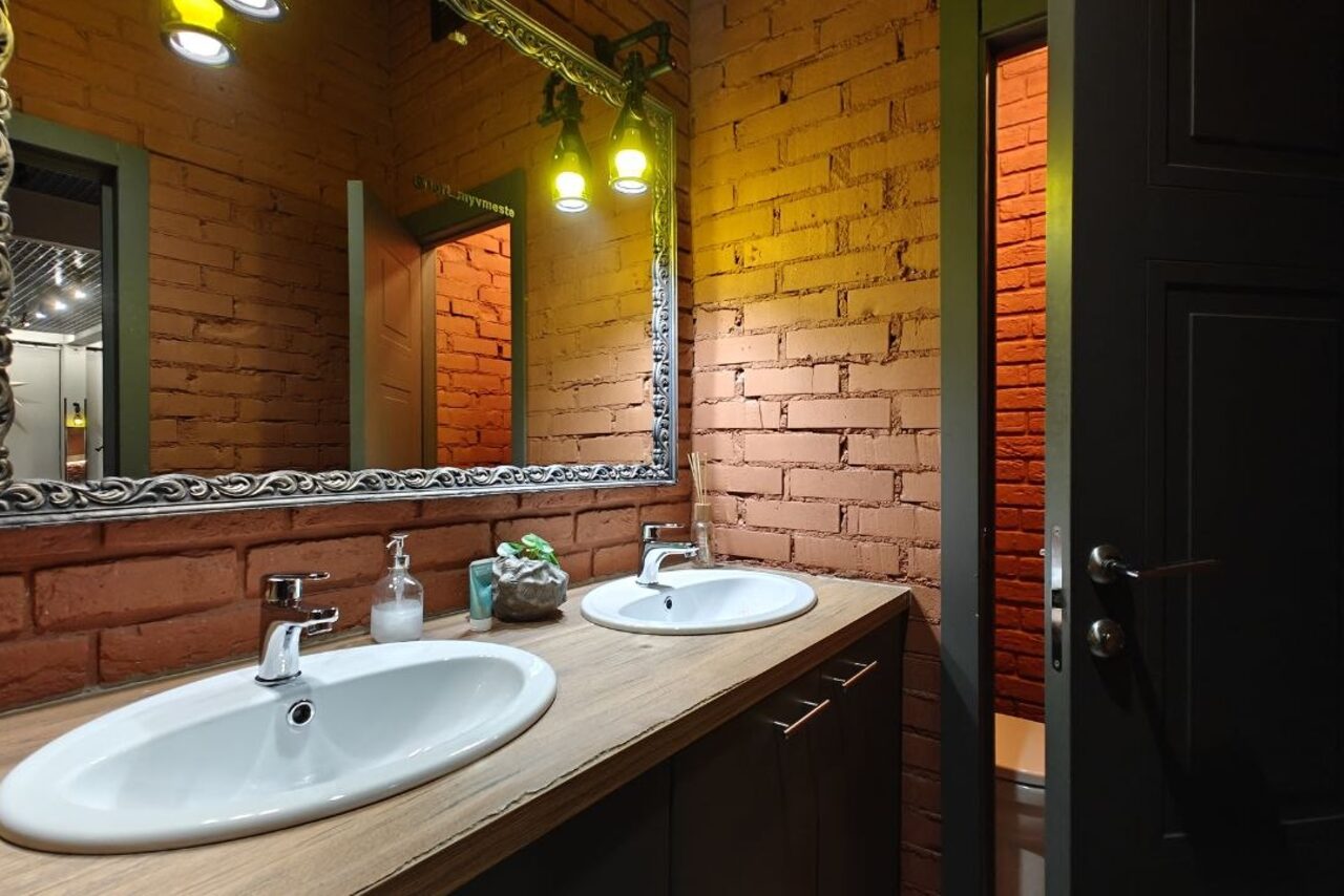 Арендовать Stylish duplex loft. Двое мужчин играют на гитарах, сидя на стульях