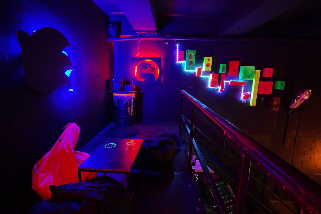 Арендовать Лофт Геймеры. Игровые арт-иконки. Неоновая подсветка. Украшенная бочка. Лестница на первый этаж. Стол с пуфами